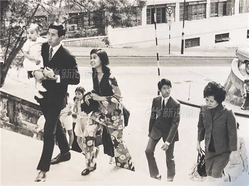 1971年，跑马地，父亲抱着两岁大的我出席婚礼，母亲一旁跟随，脸上洋溢着灿烂的笑容。记忆中，父亲陪伴的日子不多。他没有接受过良好教育，靠自学成为白领，节假日也常常忙于加班，是一位为了养活家人而努力工作的典型港人。在那个相机并不普及的年代，这张旧照显得尤为珍贵。