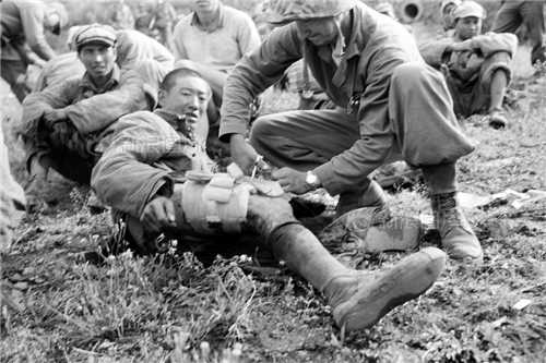 据丹东市抗美援朝战争纪念馆统计，志愿军直接战斗牺牲的人数为183108人，大约有18万志愿军烈士安葬在朝鲜。在战斗中，志愿军被俘人数在21400人左右。其中6000余人回到大陆。图为1951年5月，美军为被俘的志愿军疗伤。